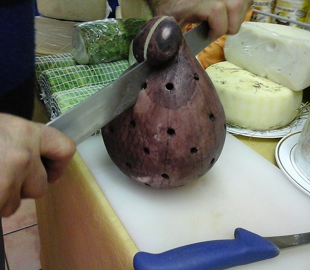 Le mani che tagliano una forma di caciocavallo