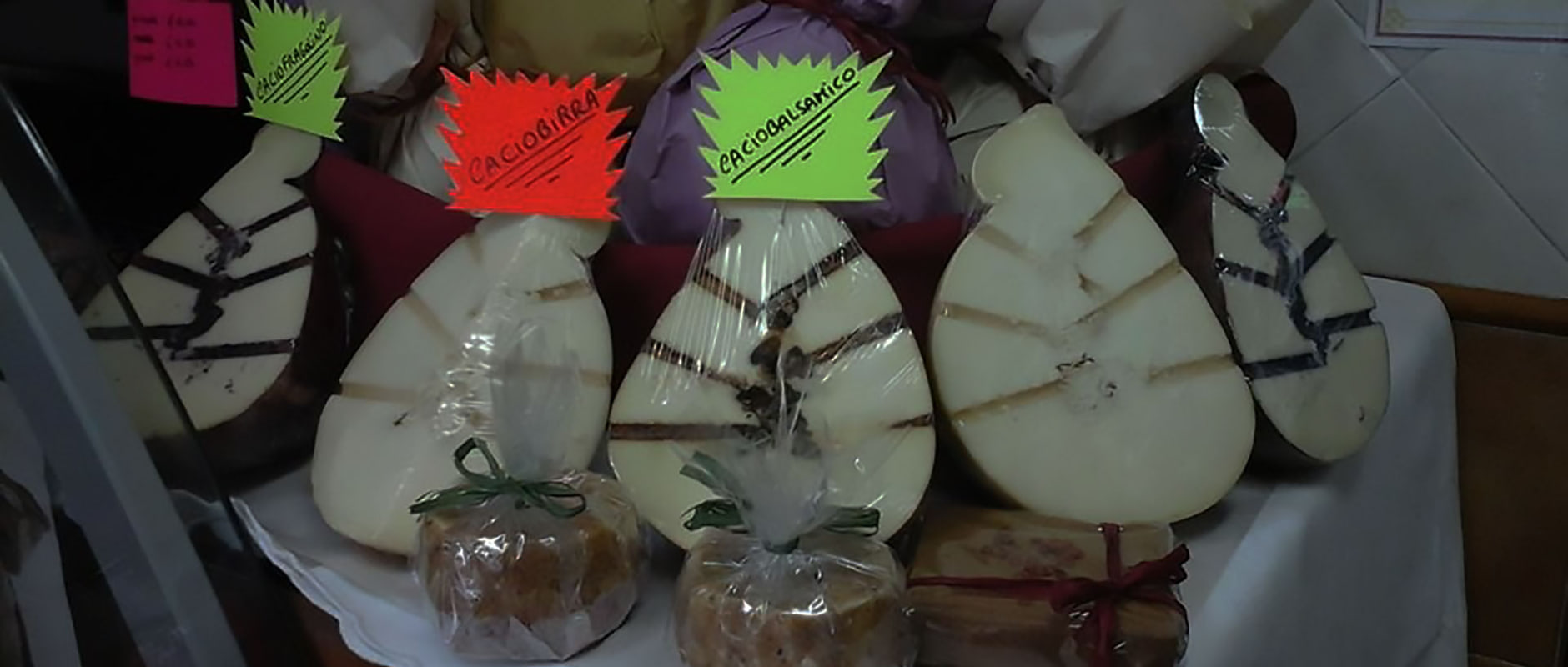 Le forme di formaggio esposte con i cartellini